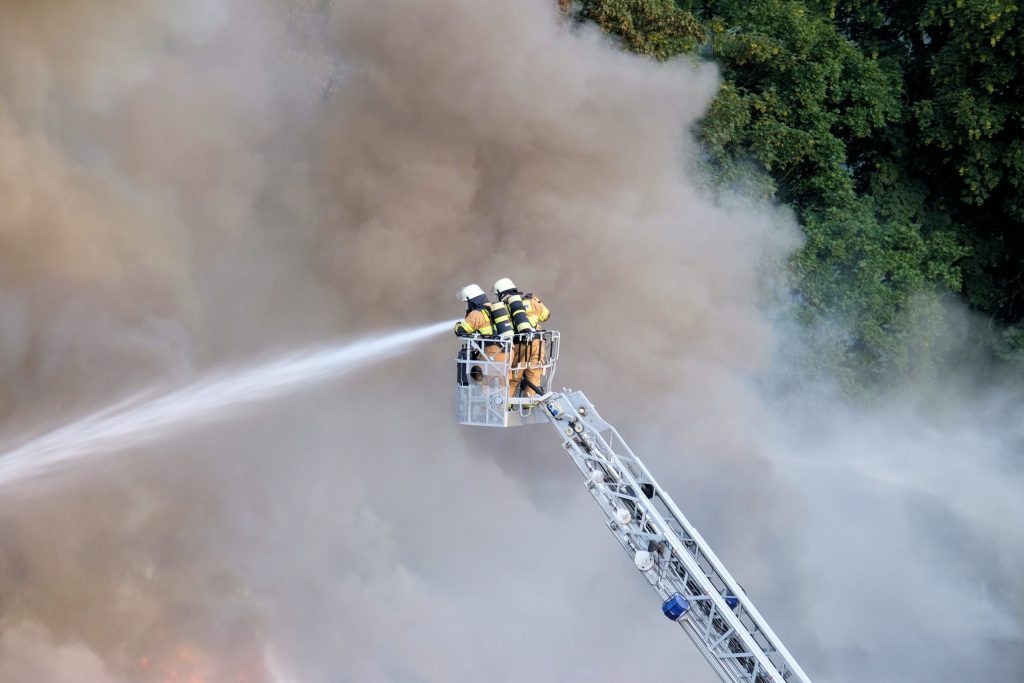 two firefighters trying stop fire forest surrounded by smoke scaled 1